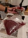 Ein durchsichtiger Plastiksack, halb gefüllt mit rotem Traubensaft